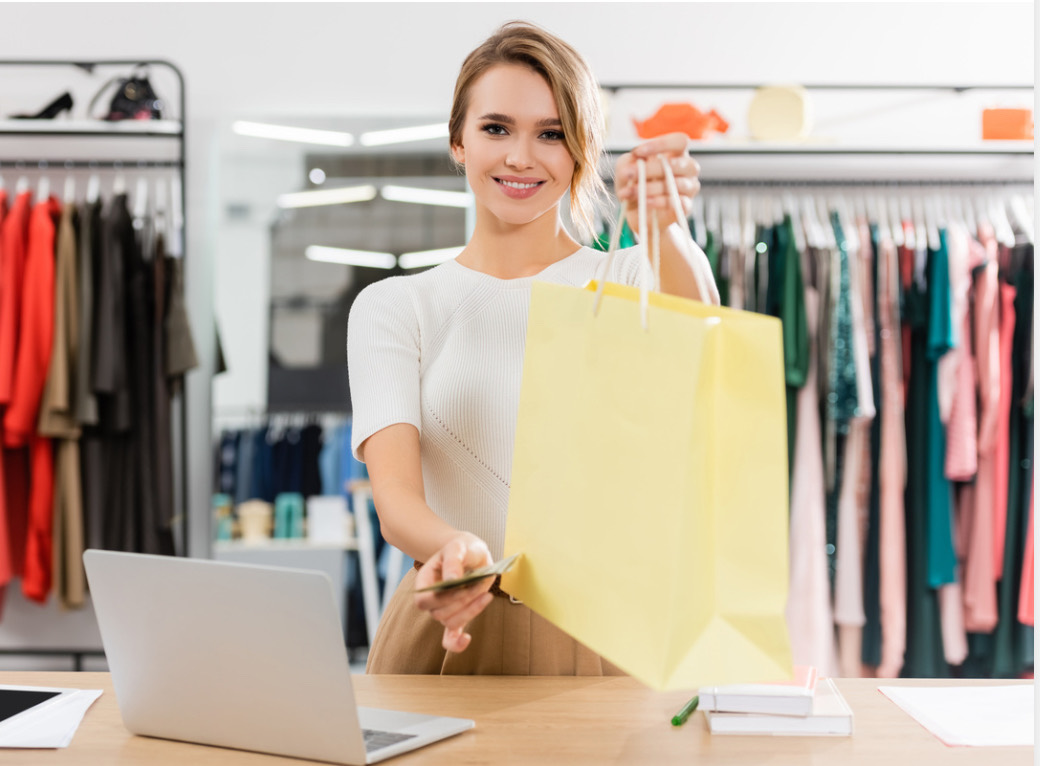 Conseillère de vente remettant un sac à une cliente en magasin