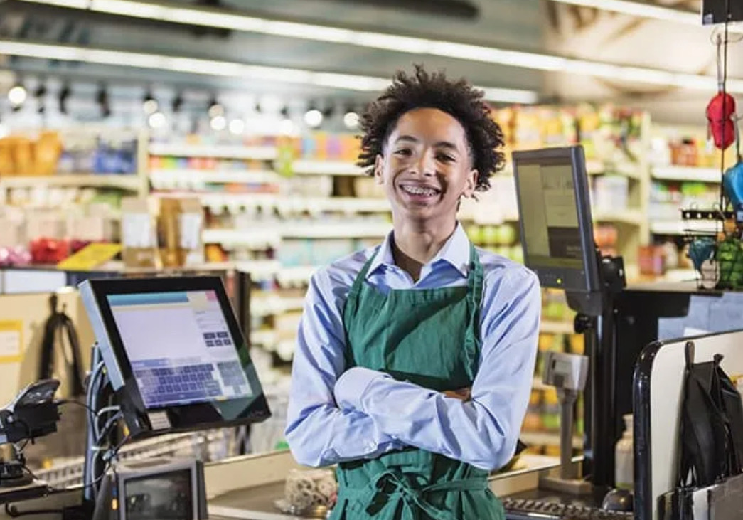 Employé commercial souriant à son poste de caisse